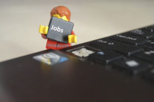 Lego man Holding a job key from a keyboard